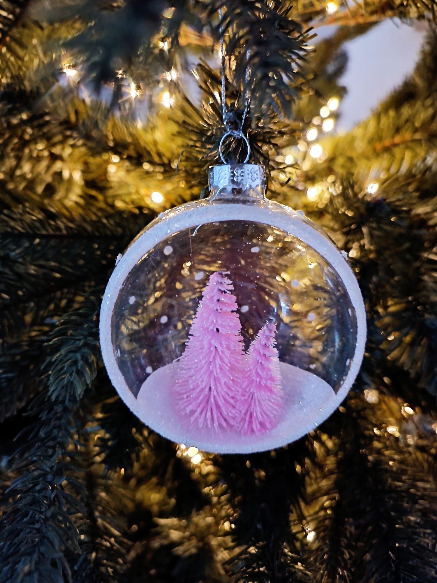 Glaskugel mit rosa Tannenbäumen